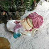 Little Mermaid Sleeping in a Seashell on White Beach Sand